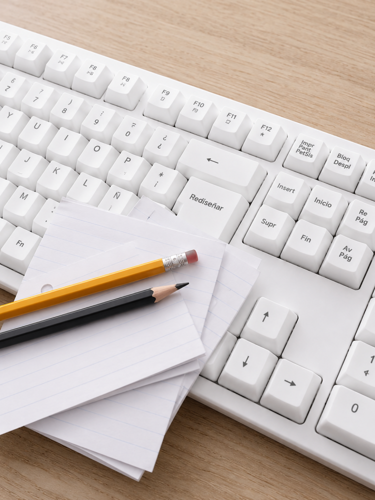 Teclado blanco con la tecla "Rediseñar" destacada, acompañado de hojas y lápices sobre el teclado, representando la reconstrucción institucional y el proceso de actualización de los estatutos de Fundación Equicentro en la Región del Maule.